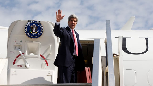 Kerry steigt ins Flugzeug, er winkt.