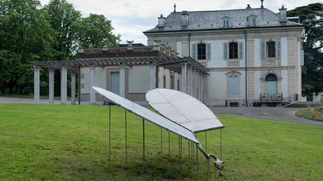 Vor einem historischen Gebäude steht eine Brunnen-Installation. Vor einem historischen Gebäude steht eine Brunnen-Installation.