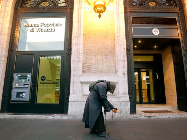 Ein Bettler vor einer Bank. Ein Bettler vor einer Bank.