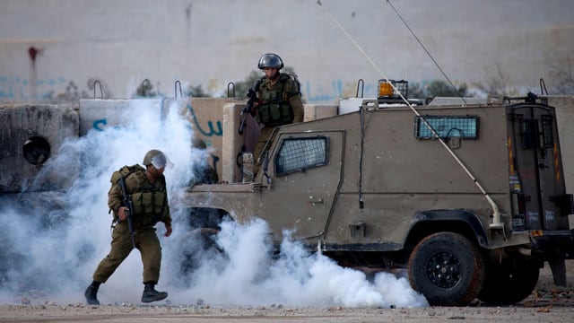 Ein israelischer Soldat vor einem Militärfahrzeug Ein israelischer Soldat vor einem Militärfahrzeug