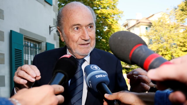 Blatter spricht in ihm entgegengehaltene Medien-Mikrofone. Blatter spricht in ihm entgegengehaltene Medien-Mikrofone.
