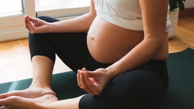 Eine schwangere Fra im Yoga.