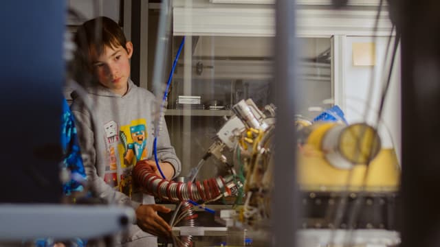 Ein Kind schaut sich ein wissenschaftliches Instrument an. Ein Kind schaut sich ein wissenschaftliches Instrument an.