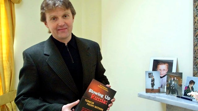 Alexander Litwinenko im Jahr 2002 mit einem Buch in der Hand. Alexander Litwinenko im Jahr 2002 mit einem Buch in der Hand.