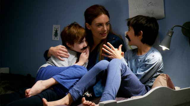 frau liest kinder im bett vor frau liest kinder im bett vor