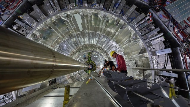 Zwei Männer reparieren den Teilchenbeschleuniger am CERN Zwei Männer reparieren den Teilchenbeschleuniger am CERN