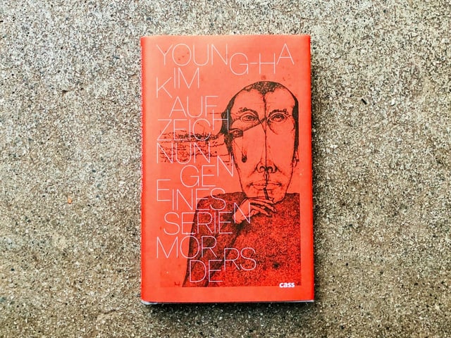 Der Krimi «Aufzeichnungen eines Serienmörders» von Kim Young-Ha liegt auf einem Zementboden Der Krimi «Aufzeichnungen eines Serienmörders» von Kim Young-Ha liegt auf einem Zementboden