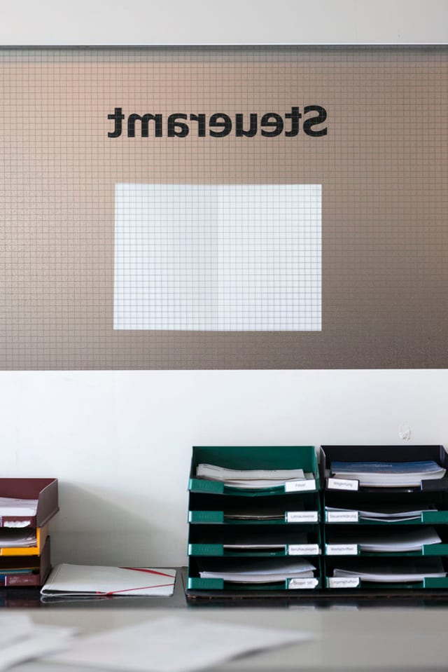 Blick in ein Büro des Steueramts mit Ablagefächern und dem Schriftzum «Steueramt» Blick in ein Büro des Steueramts mit Ablagefächern und dem Schriftzum «Steueramt»