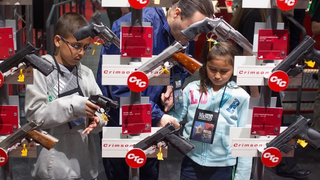 Kinder mit Eltern in einem Waffengeschäft in den USA. Kinder mit Eltern in einem Waffengeschäft in den USA.