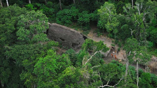 Luftbild mit Indigenen, die in einem Urwald leben. Zu sehen sind einfache Hütten und Menschen. Luftbild mit Indigenen, die in einem Urwald leben. Zu sehen sind einfache Hütten und Menschen.