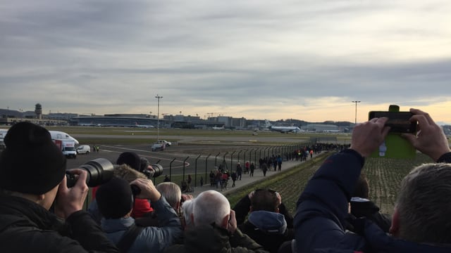 Menschen von hinten, halten Smartphones in die Höhe, weit hinten die Air Force One Menschen von hinten, halten Smartphones in die Höhe, weit hinten die Air Force One