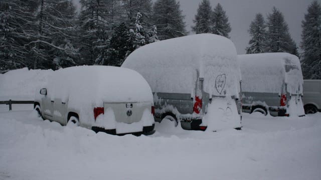 Tief verschneite Fahrzeuge in Salastrains im Engadin. Tief verschneite Fahrzeuge in Salastrains im Engadin.