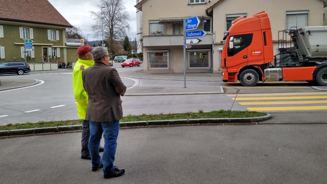 Zwei Männer stehen an einer Strasse Zwei Männer stehen an einer Strasse