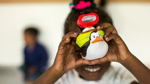Schwarzes Mädchen hält Plastikspielzeug in die Kamera Schwarzes Mädchen hält Plastikspielzeug in die Kamera