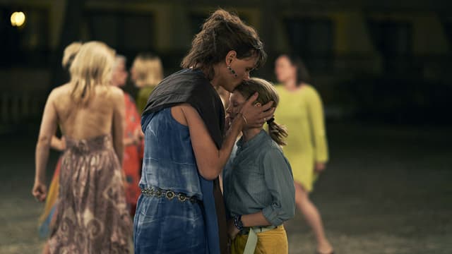Filmszene: Auf der Tanzfläche küsst eine Frau ein Mädchen auf die Stirn. Filmszene: Auf der Tanzfläche küsst eine Frau ein Mädchen auf die Stirn.