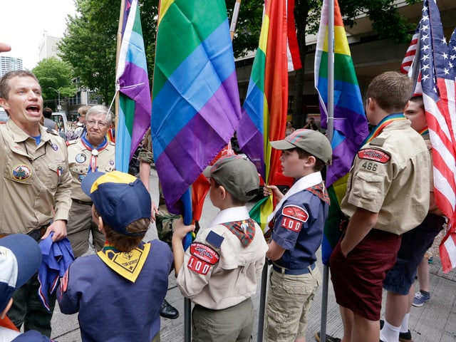 Ein Pfadfinder-Leiter und ein paar Jugendliche mit USA- und Regenbogenfahnen. Ein Pfadfinder-Leiter und ein paar Jugendliche mit USA- und Regenbogenfahnen.