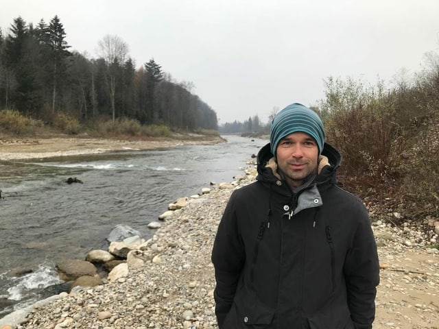 Mann mit Mütze an Fluss. Mann mit Mütze an Fluss.