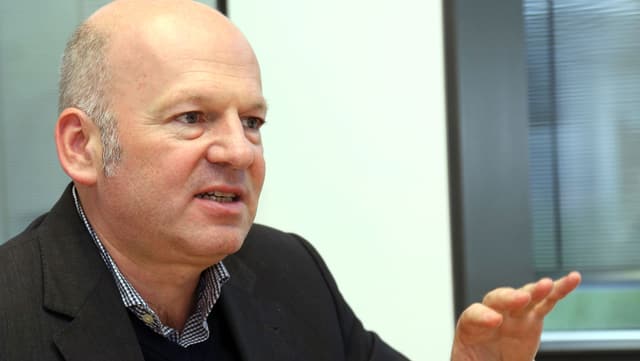 Halbnahes Bild von Joachim Buger in Hemd, Pullover und Sacko, sprechend. Halbnahes Bild von Joachim Buger in Hemd, Pullover und Sacko, sprechend.