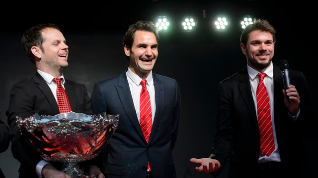 Severin Lüthi hält die Davis-Cup-Schüssel, daneben stehen breit lachend Roger Federer und Stan Wawrinka. Severin Lüthi hält die Davis-Cup-Schüssel, daneben stehen breit lachend Roger Federer und Stan Wawrinka.