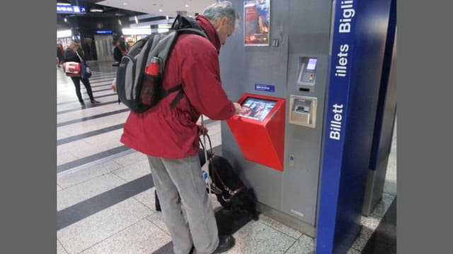 Ein blinder Mann versucht am Billettautomaten zurecht zu kommen. Ein blinder Mann versucht am Billettautomaten zurecht zu kommen.
