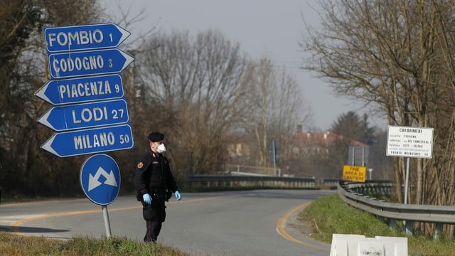Carabinieri steht an Strassenkreuzung mit Schildern. Carabinieri steht an Strassenkreuzung mit Schildern.