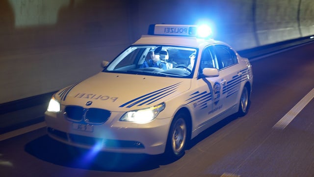Polizeiauto fährt auf Strasse Polizeiauto fährt auf Strasse