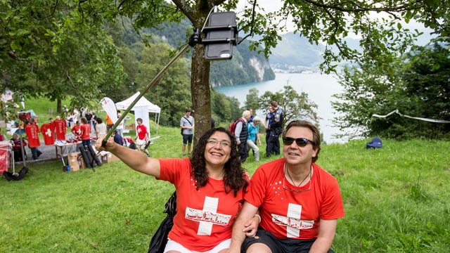 Eine Frau und ein Mann in rot-weissen Schweizershirts machen ein Selfie. Eine Frau und ein Mann in rot-weissen Schweizershirts machen ein Selfie.