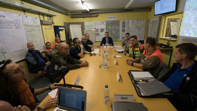 Grosser Sutzungstisch, darum Militärs und Zivilschützer. Grosser Sutzungstisch, darum Militärs und Zivilschützer.