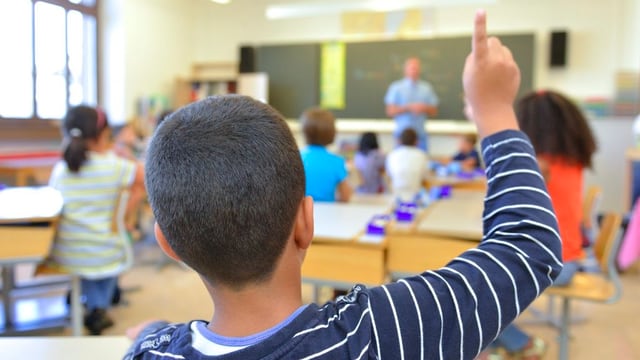 Schüler hebt im Unterricht den Finger. Schüler hebt im Unterricht den Finger.