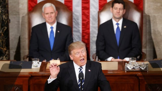 Trump hält eine Rede. Hinter ihm sind Vizepräsident Mike Pence und der Sprecher des Räpresentantenhauses, Paul Ryan. Trump hält eine Rede. Hinter ihm sind Vizepräsident Mike Pence und der Sprecher des Räpresentantenhauses, Paul Ryan.