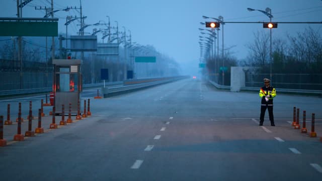 Polizist auf einer einsamen Strassenkreuzung im Industriekomplex Kaesong, Nordkorea. Polizist auf einer einsamen Strassenkreuzung im Industriekomplex Kaesong, Nordkorea.