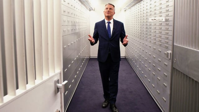 Moderator Reto Lipp geht in der Sendung «ECO Spezial»: Private Banking – Die Party ist zu Ende durch einen Tresorraum. Moderator Reto Lipp geht in der Sendung «ECO Spezial»: Private Banking – Die Party ist zu Ende durch einen Tresorraum.