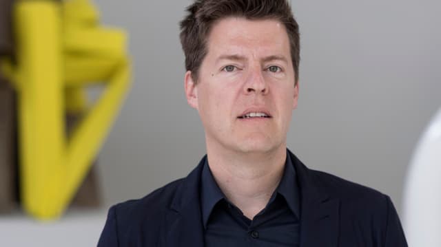 Ein Porträt von Philipp Kaiser. Er wird von Kunstwerken umrahmt. Ein Porträt von Philipp Kaiser. Er wird von Kunstwerken umrahmt.