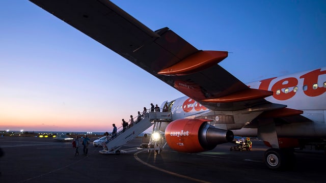 Easyjet-Flieger auf Landebahn, aussteigende Passagiere Easyjet-Flieger auf Landebahn, aussteigende Passagiere