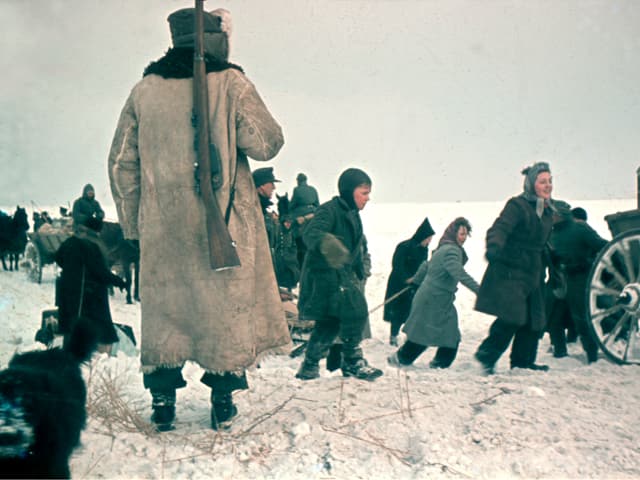 Menschen im Schnee. Sie tragen warme Kleider. Sie sind auf der Flucht. Menschen im Schnee. Sie tragen warme Kleider. Sie sind auf der Flucht.