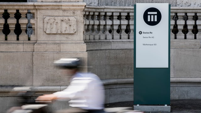 Eine Person fährt mit dem Roller an Swiss Re vorbei. Eine Person fährt mit dem Roller an Swiss Re vorbei.