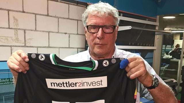 Mann zeigt Fussballtrikot Mann zeigt Fussballtrikot