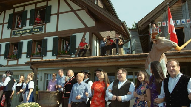 Schunkelde Menschen vor Landgasthof mit Musikanten die aus Fenstern herausschauen. Schunkelde Menschen vor Landgasthof mit Musikanten die aus Fenstern herausschauen.