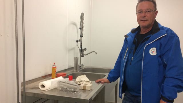 Mann steht vor Abwaschbecken. Mann steht vor Abwaschbecken.