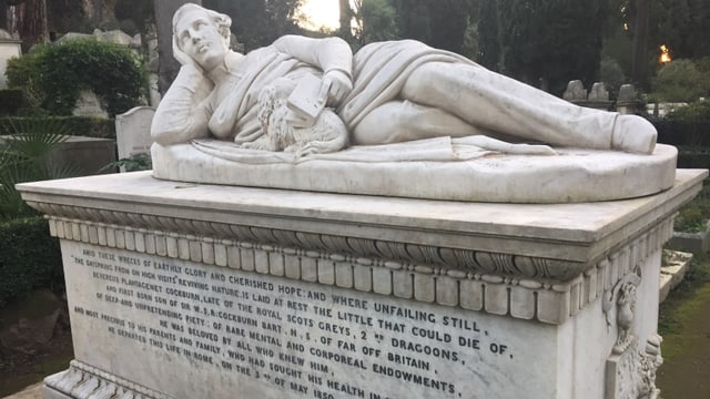 Ein Grabstein mit der Skulptur eines Mannes. Ein Grabstein mit der Skulptur eines Mannes.