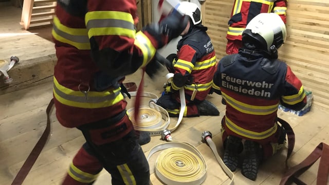 Männer in Feuerwehruniform mit Schläuchen. Männer in Feuerwehruniform mit Schläuchen.