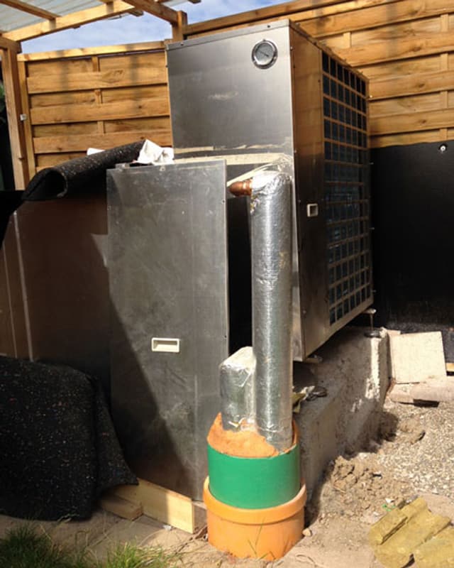 Eine grosse, unförmige Pumpanlage aus Metall in einem Holzverschlag. Eine grosse, unförmige Pumpanlage aus Metall in einem Holzverschlag.
