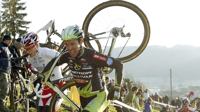 Ralph Näf rennt mit dem Bike auf dem Buckel einen Hang hinauf. Ralph Näf rennt mit dem Bike auf dem Buckel einen Hang hinauf.