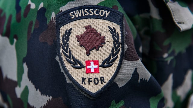 Swisscoy-Annäher an einem Tarnanzug. Swisscoy-Annäher an einem Tarnanzug.