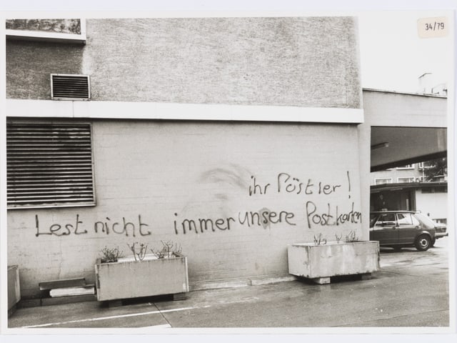 An der Wand steht: «Ihr Pöstler! Lest nicht immer unsere Postkarten.» An der Wand steht: «Ihr Pöstler! Lest nicht immer unsere Postkarten.»