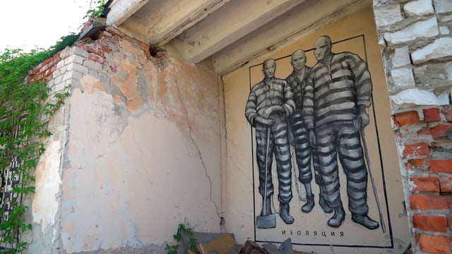 Graffiti von drei Häftlingen an einer zerfallenen Hauswand Graffiti von drei Häftlingen an einer zerfallenen Hauswand