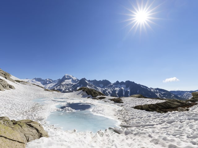 Sonniges Wetter in alpiner Umgebung mit Schnee.