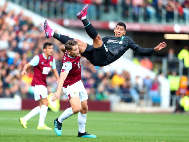 Roberto Firmino fliegt durch die Luft.