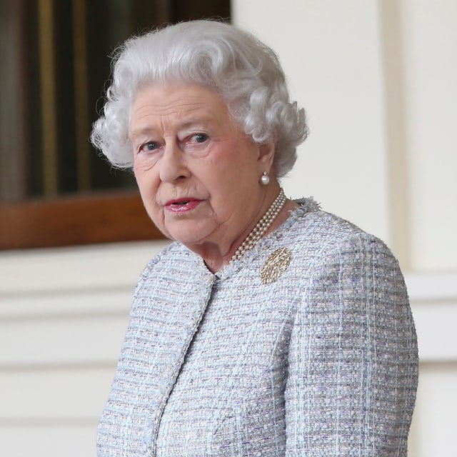 Die Queen ernst in die Kamera blickend. Die Queen ernst in die Kamera blickend.