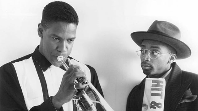 Denzel Washington spielt Trompete. Spike Lee schaut ihm dabei zu. Denzel Washington spielt Trompete. Spike Lee schaut ihm dabei zu.